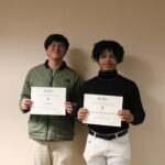 Two men holding their certificates.