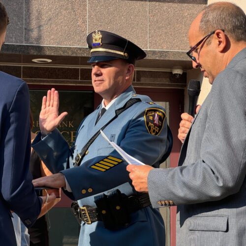 Mayor Billy Portman (right) administers the oath of office to Red Bank Police Chief Michael Frazee while Frazee’s son Michael holds the Bible. (Photo by Brian Donohue. Click to enlarge.)