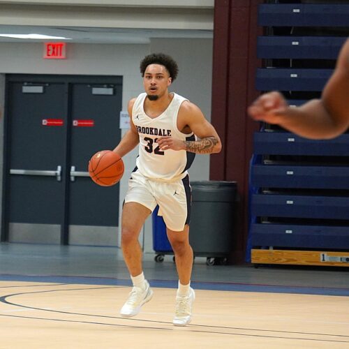 Man dribbling a basketball down the court.